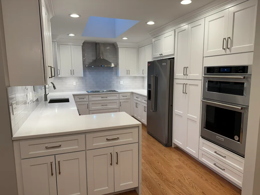 White custom kitchen cabinets with range wall, island, and built-in appliances